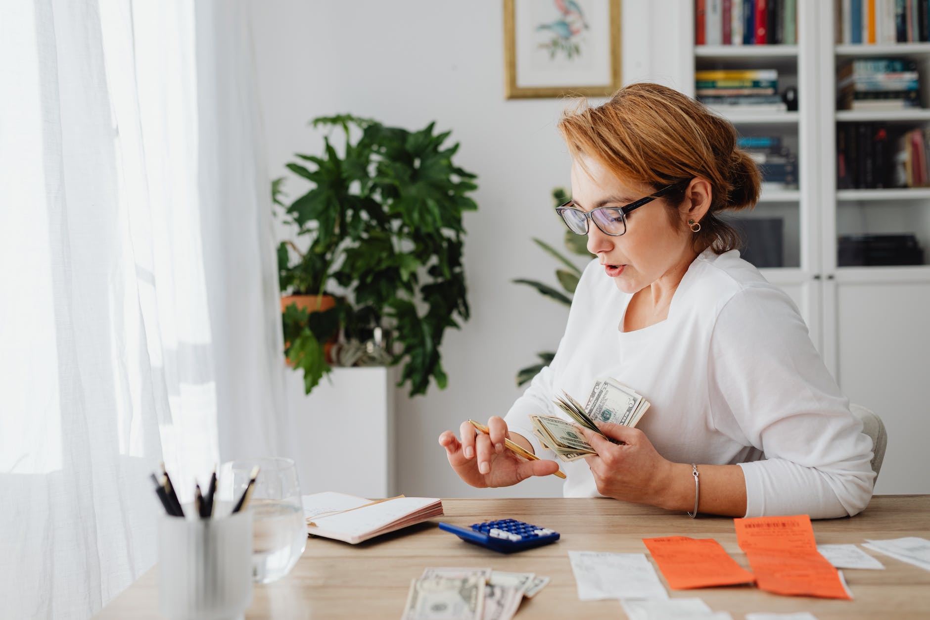 woman sitting at desk counting money