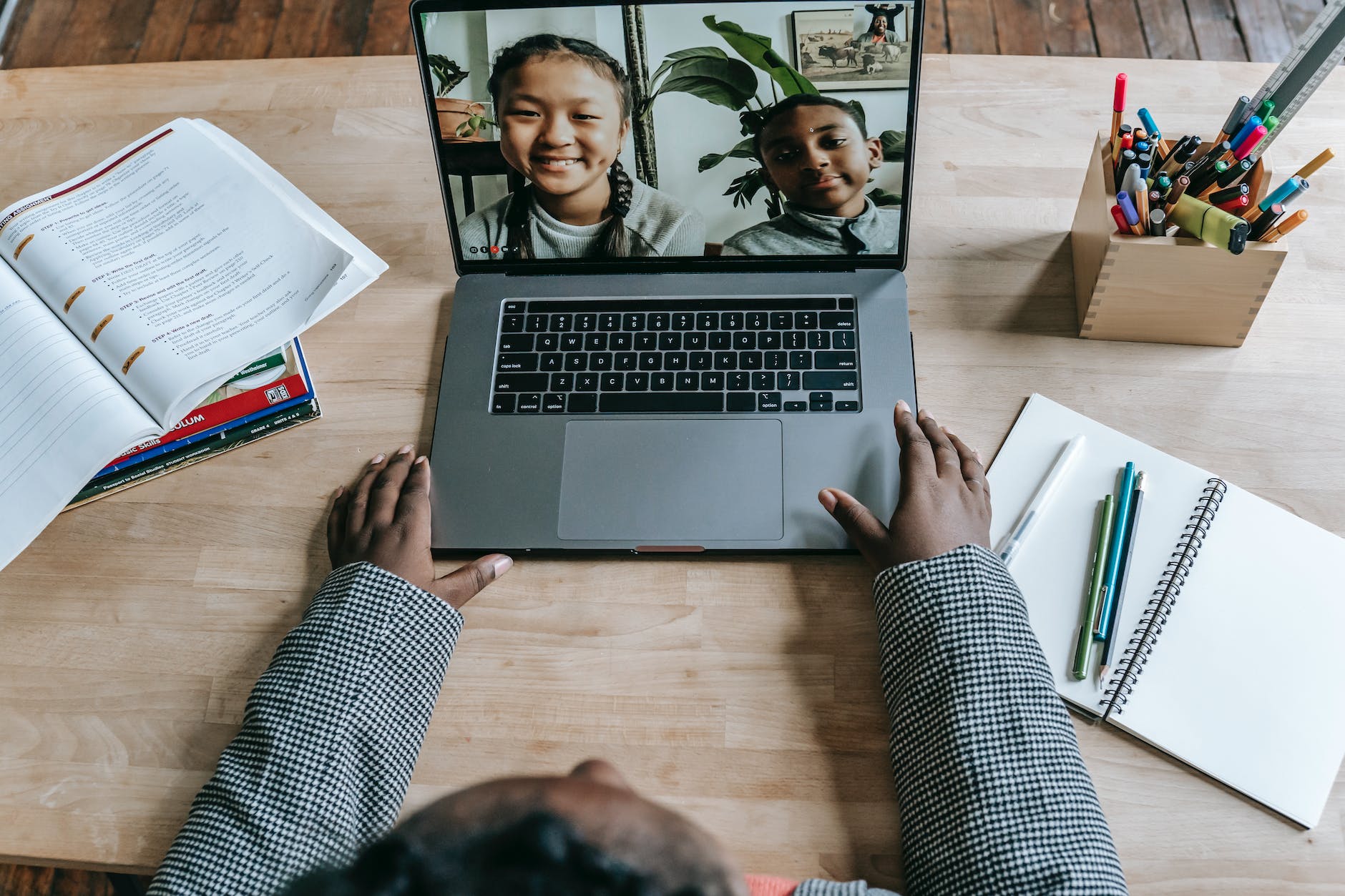 black teacher using laptop and having online lesson with pupils